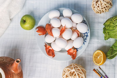 Directly above shot of eggs in plate amidst fruits on table