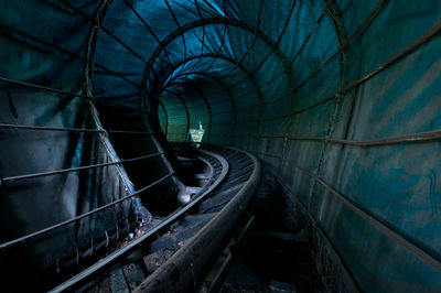 Railroad tracks in illuminated tunnel