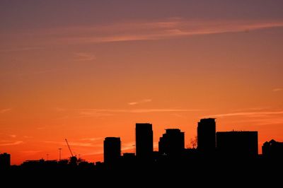 Silhouette buildings against sky during sunset