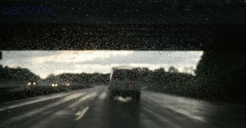 Raindrops on road seen through wet window