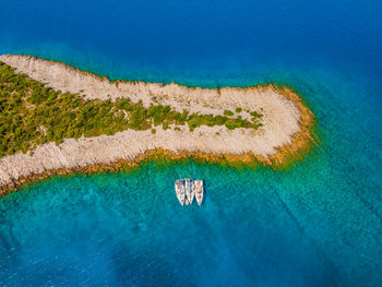 Overhead aerial view of sailing yachts anchored in a remote bay in croatia.