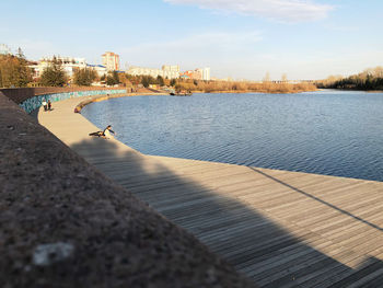 Scenic view of river by city against sky