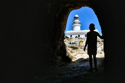 Rear view of silhouette man standing on rock