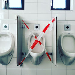 Empty urinal with social distancing sign