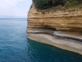 Scenic view of rock formation in sea against sky