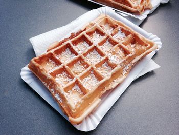 High angle view of powered sugar waffel on paper plate