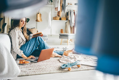 Woman using laptop sitting at home