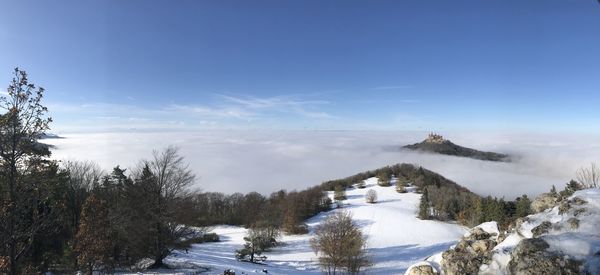 Scenic view of snow covered landscape against blue sky