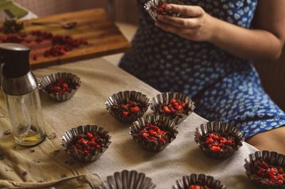 Midsection of woman with fruits on table