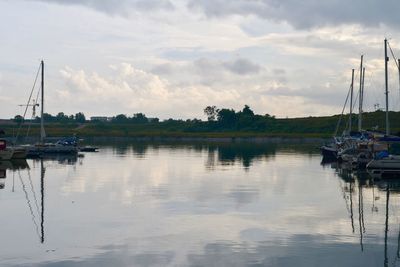 Boats moored in lake against sky