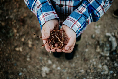 Close-up of man holding umbrella on land