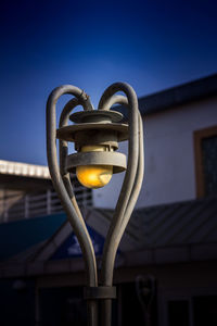 Low angle view of illuminated lamp against clear blue sky