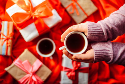 Close-up of hand holding coffee cup on table