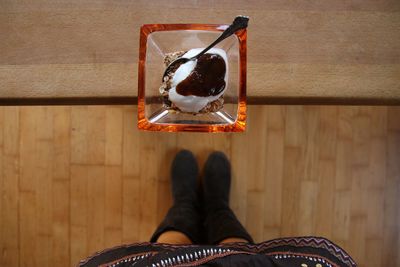 Low section of woman standing on wooden floor