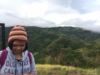 Portrait of smiling girl on land against sky