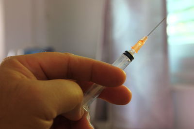 Close-up of hand holding syringe