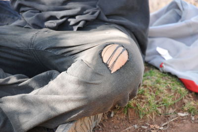Low section of man relaxing on field