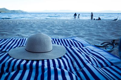 Sun hat on striped blanket at beach
