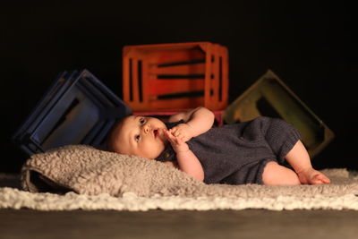 Baby boy lying on rug at home