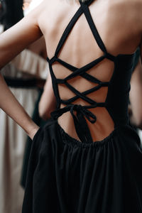 Elegant feminine fashion details of spring summer black dress with lace up back. back view