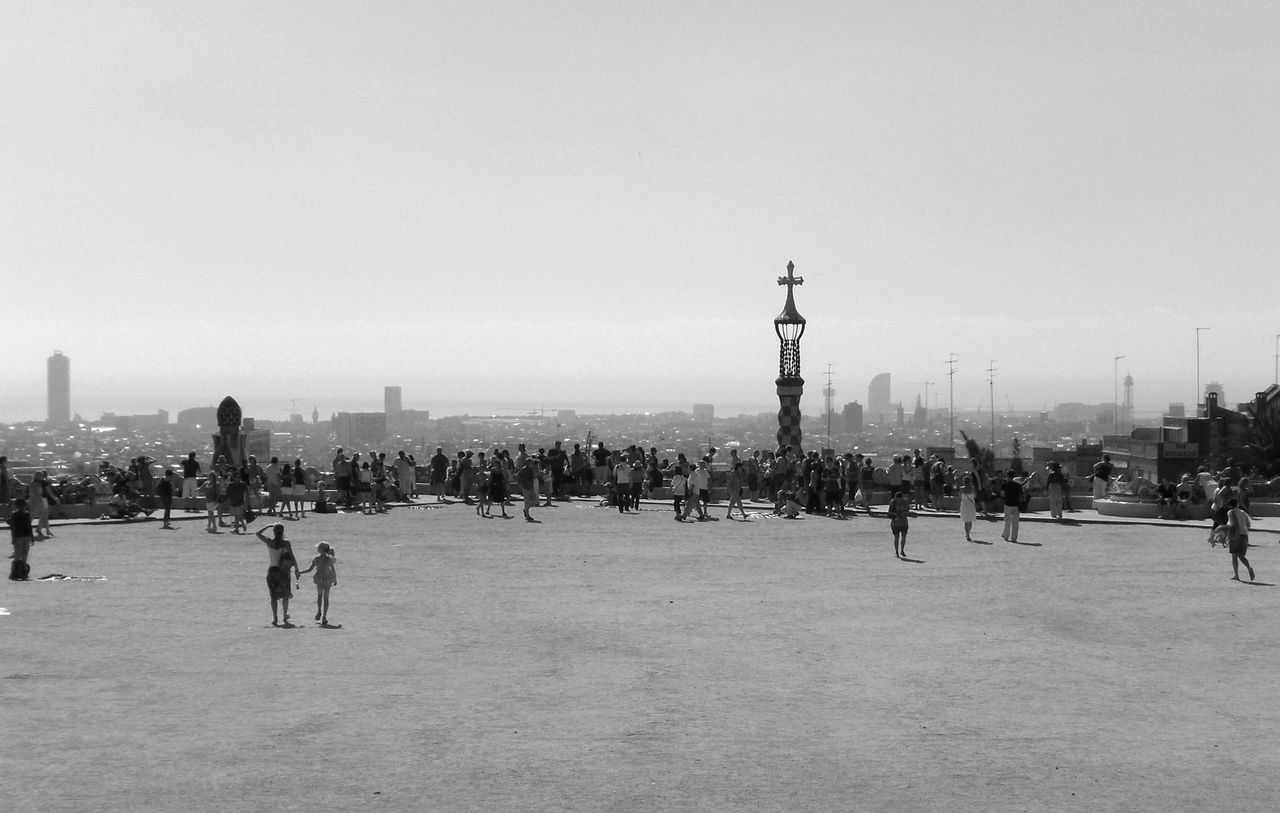 large group of people, clear sky, city, copy space, architecture, built structure, building exterior, men, person, city life, street, mixed age range, lifestyles, leisure activity, walking, outdoors, sky, travel, street light