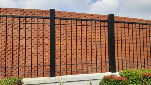 Low angle view of fence against orange sky