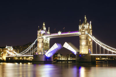 Suspension bridge over river at night