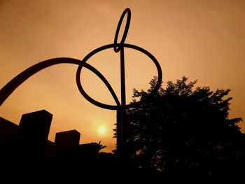 Low angle view of silhouette built structure against sky at sunset