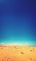 Scenic view of desert against clear blue sky