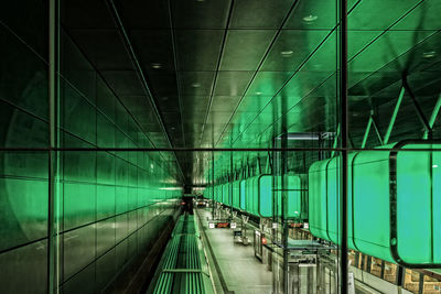 Illuminated green lights at hafencity universitat seen through glass