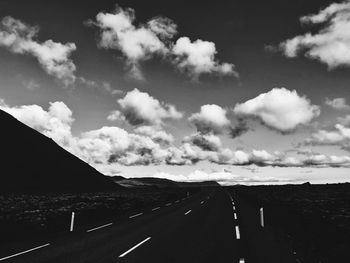 Empty road against cloudy sky