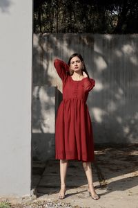 Young woman standing against trees