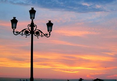 Low angle view of street light against orange sky