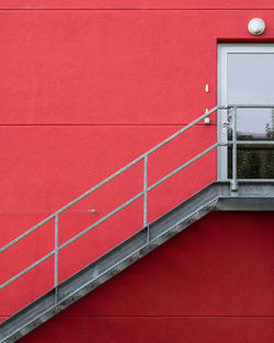 Low angle view of building against red wall