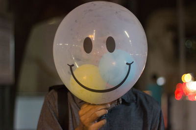 Man holding balloon at home