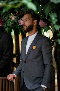 Young man standing by flowering plants