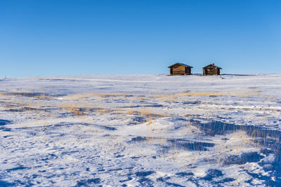 Scenic view of snow covered land against clear blue sky