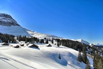 Scenic view of snowcapped mountains against clear blue sky