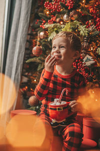 Portrait of young woman blowing bubbles at home