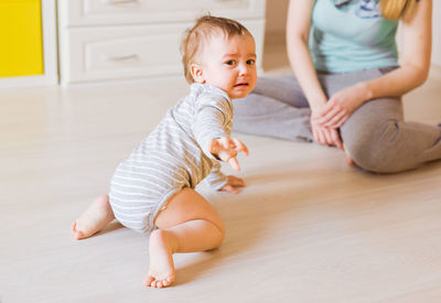 Cute baby girl lying on floor at home