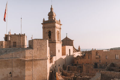 Buildings in city against clear sky