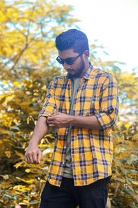 Side view of young man standing in forest