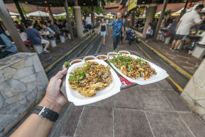 People holding food on street in city