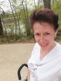 Portrait of smiling young woman standing on land