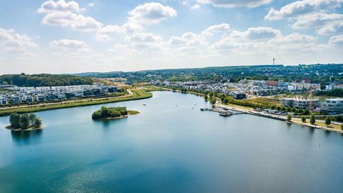 Aerial view of bridge over river in city against sky