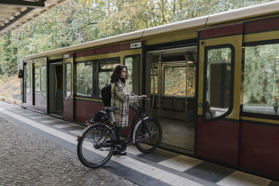 Woman with bicycle entering an underground train, berlin, germany