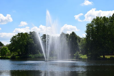 Fountain and trees against sky