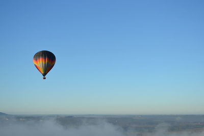 Hot air balloon flying against clear blue sky