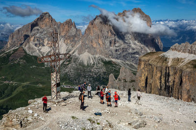 People on rocks against mountain range