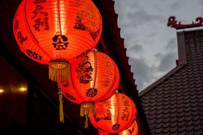 Low angle view of illuminated lanterns hanging on wall